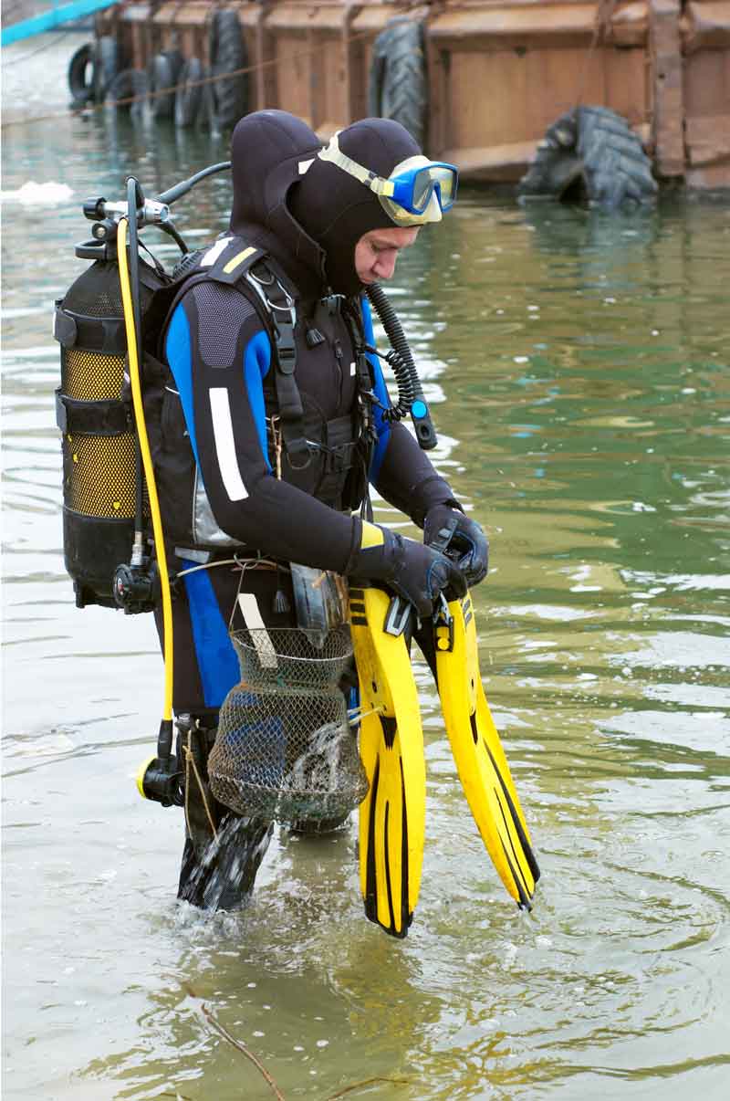 179601_scuba-diver-entering-the-water a-diving-equipment-with-regulators-and-tools-for-checking-barrels.